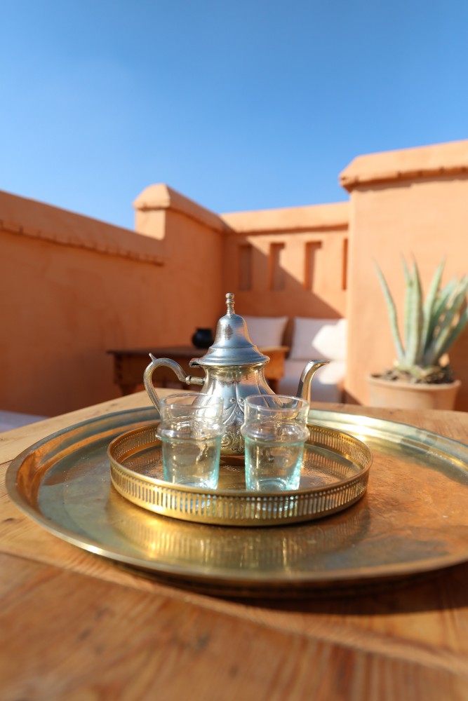 Théière et verres sur leur plateau de laiton, posés sur la terrasse du riad, prêts pour une arrivée
